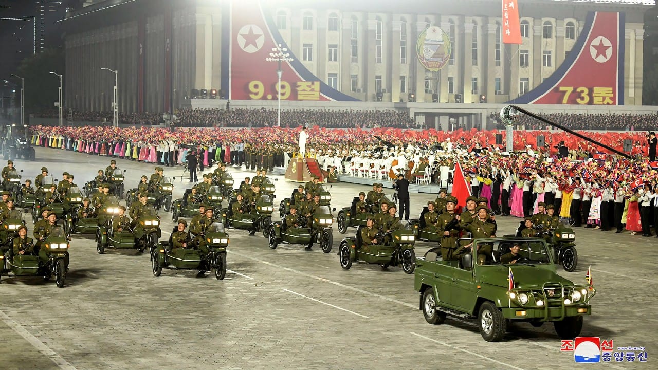 Civil defense forces carrying rifles and personnel wearing gas masks and red hazmat suits paraded North Korea’s capital overnight in a celebration of the nation’s 73rd anniversary that was a marked departure from past militaristic displays. (Image: Korean Central News Agency/Korea News Service via AP)