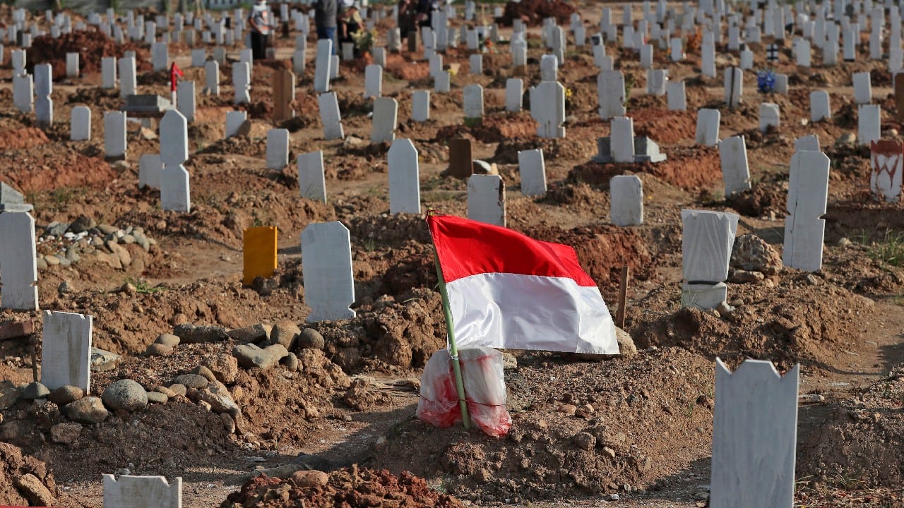 Pops of color stand out in the sea of brown earth, helping future visitors find their loved ones. Other graves have photos of the dead, wrapped in plastic to protect against the elements. (Image: AP) Pops of color stand out in the sea of brown earth, helping future visitors find their loved ones. Other graves have photos of the dead, wrapped in plastic to protect against the elements. (Image: AP)