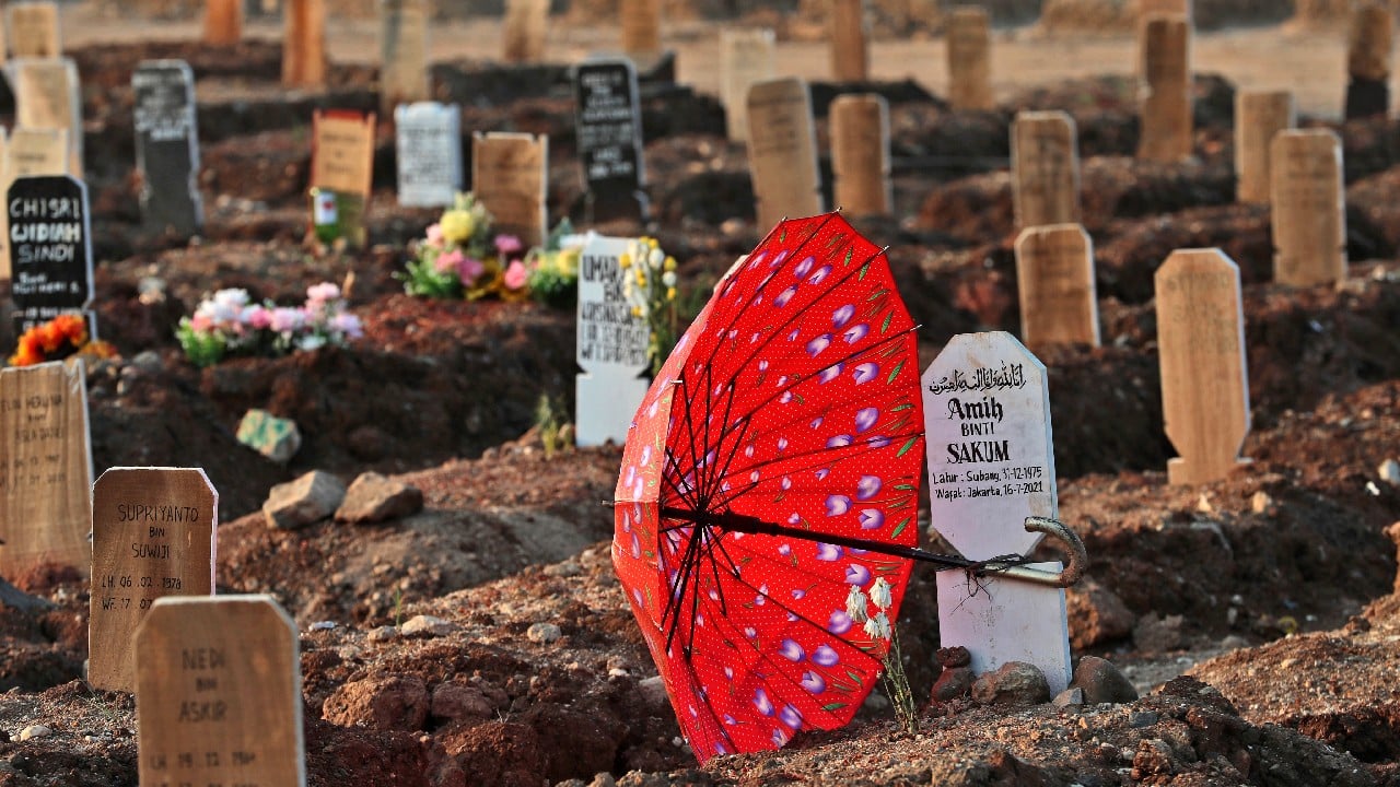 Here, one grave is covered in a rainbow of flowers; further on, a large red umbrella is securely fastened to a headstone to keep from blowing away. Red and white Indonesian flags are planted proudly beside many others. (Image: AP) Here, one grave is covered in a rainbow of flowers; further on, a large red umbrella is securely fastened to a headstone to keep from blowing away. Red and white Indonesian flags are planted proudly beside many others. (Image: AP)