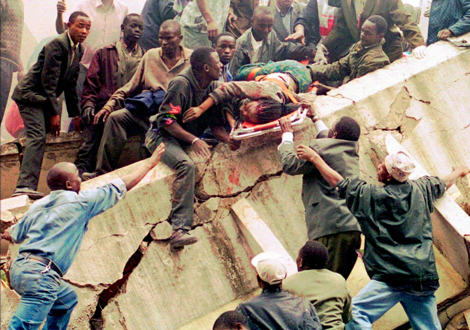 FILE - In this Friday, Aug. 7, 1998 file photo, rescue workers carry Susan Francisca Murianki, a U.S. embassy office worker, over the rubble of a collapsed building next to the embassy, in Nairobi, Kenya. In 1996, Osama bin Laden issued a formal declaration of war. But it wasn't until trucks loaded with explosives detonated outside of U.S. embassies in Nairobi and Dar es Salaam, Tanzania, killing more than 200 people on Aug. 7, 1998, that the threat became real. (AP Photo/Khalil Senosi, File)