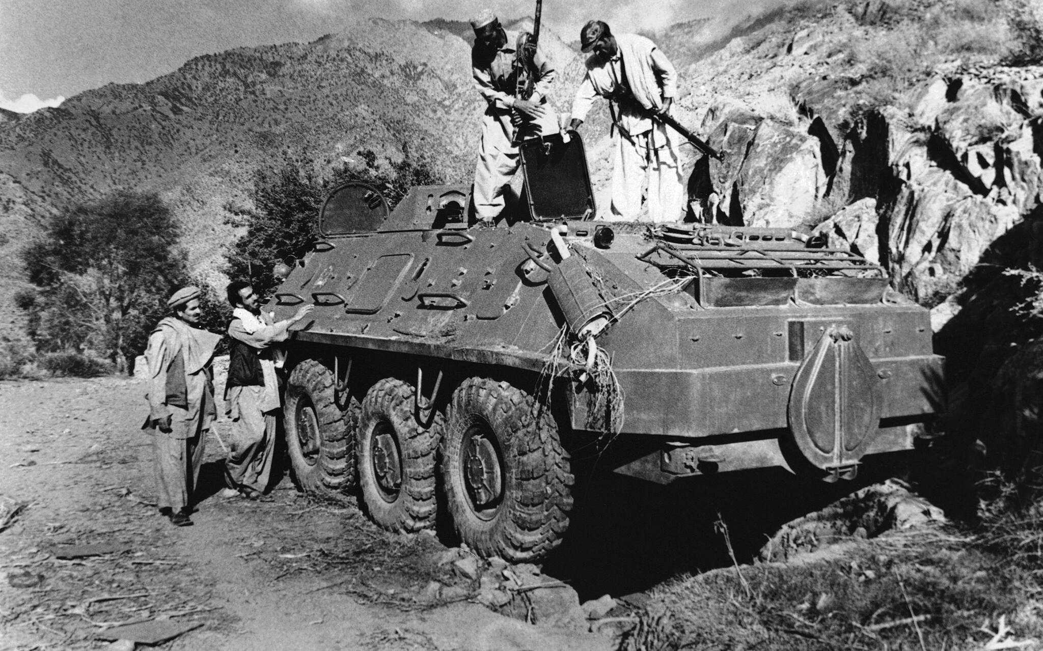 FILE - In this Dec. 27, 1979 file photo, rebel Muslim fighters inspect a Soviet tank captured in fighting with the Kabul government forces on September near Asmar, Afghanistan. Al-Qaida, or “the Base” in Arabic, organized as the Soviets pulled out of Afghanistan. Hoping to capitalize on the support the mujahedeen, or the “holy warriors,” received during their war against Moscow, Osama bin Laden formed al-Qaida and became its leader. (AP Photo/Steve McCurry, File)