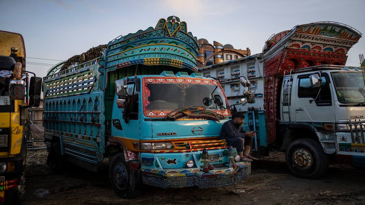 A truck driver checks his phone at a parking lot in Kabul, Afghanistan. (AP Photo/Bernat Armangue)