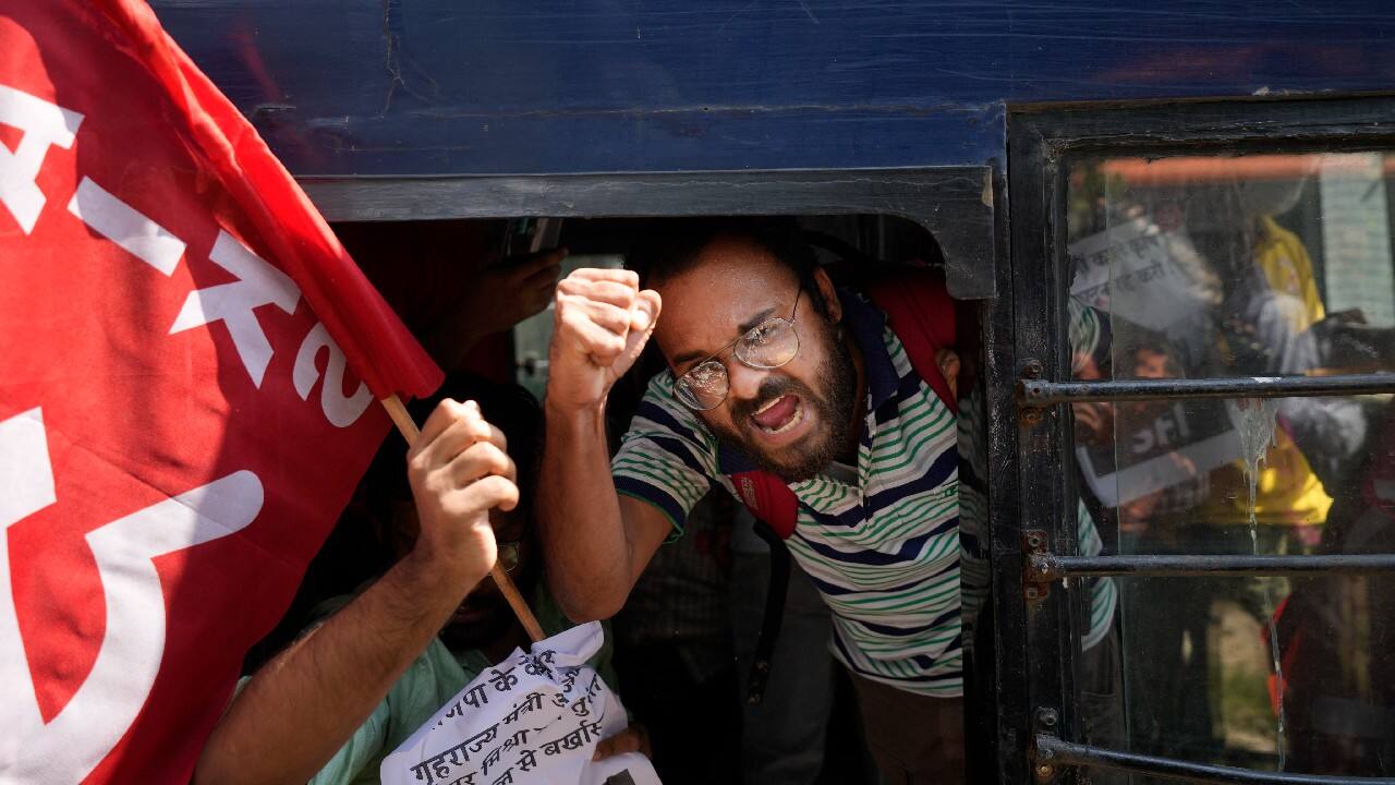 A Communist party of India activist shouts slogans as he is taken away with others in a police vehicle during a protest against the Sunday's killing of four farmers in Uttar Pradesh state after being run over by a car owned by India's junior home minister in New Delhi, October 4. (Image: AP)