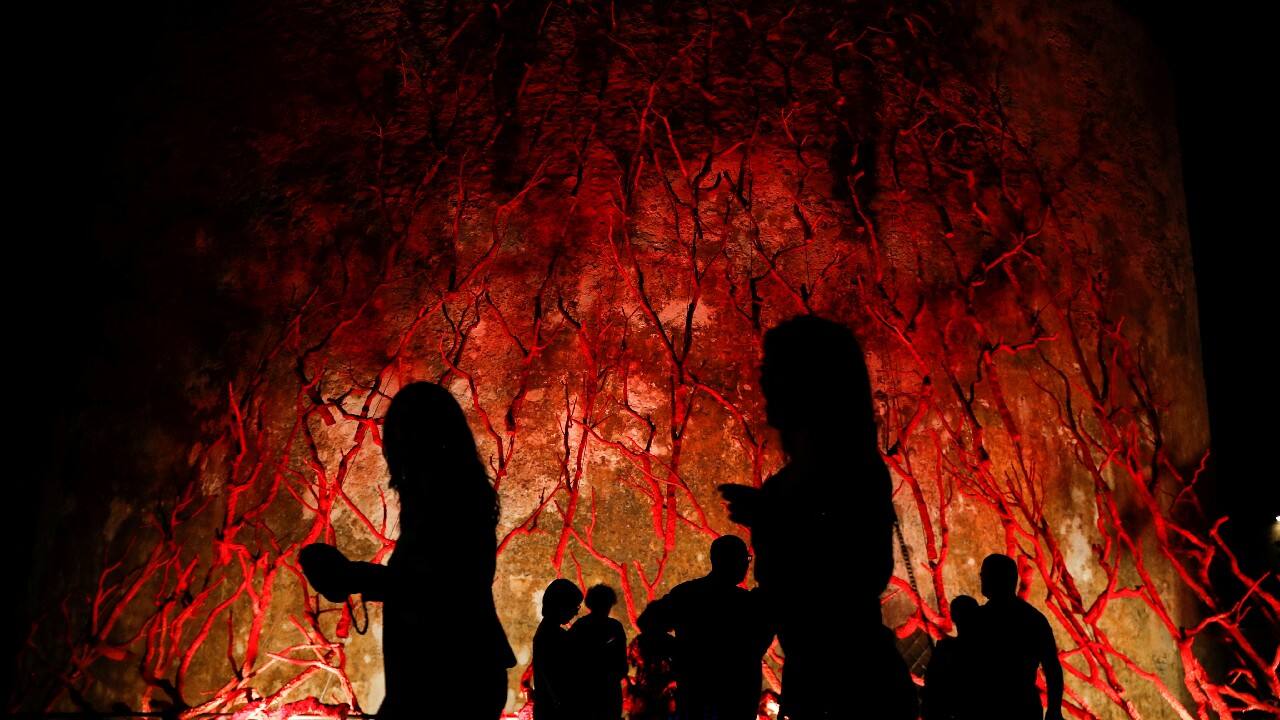 People walk in front of an art installation called "L'albero di corallo" (Coral tree), in Alghero, Italy, September 25. (Image: Reuters)