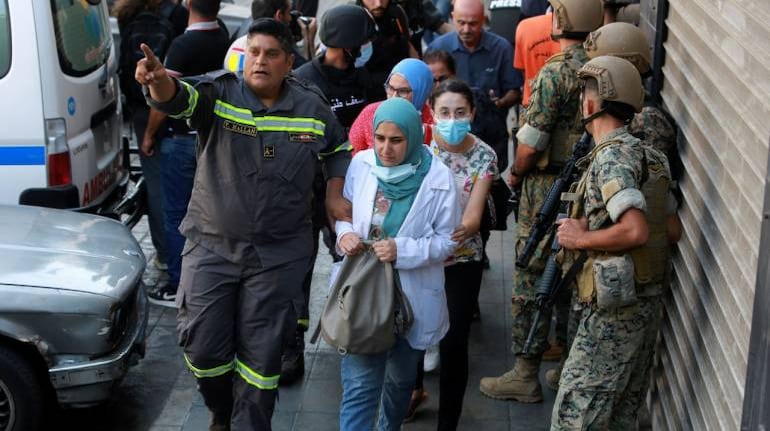 A civil defence member helps evacuate civilians after gunfire erupted in Beirut, Lebanon October 14, 2021. (Image: REUTERS/Aziz Taher)