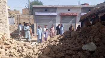 Residents gather near the rubble of a damaged house following an earthquake in Harnai, Balochistan, Pakistan, October 7, 2021. (Image: REUTERS/Naseer Ahmed)