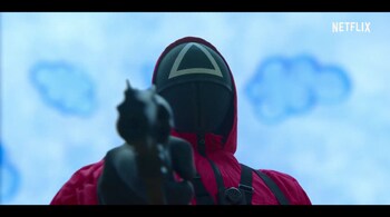 The soldiers in 'Squid Game' wear fuchsia pink suits and microphone masks. (Image: screen grab)