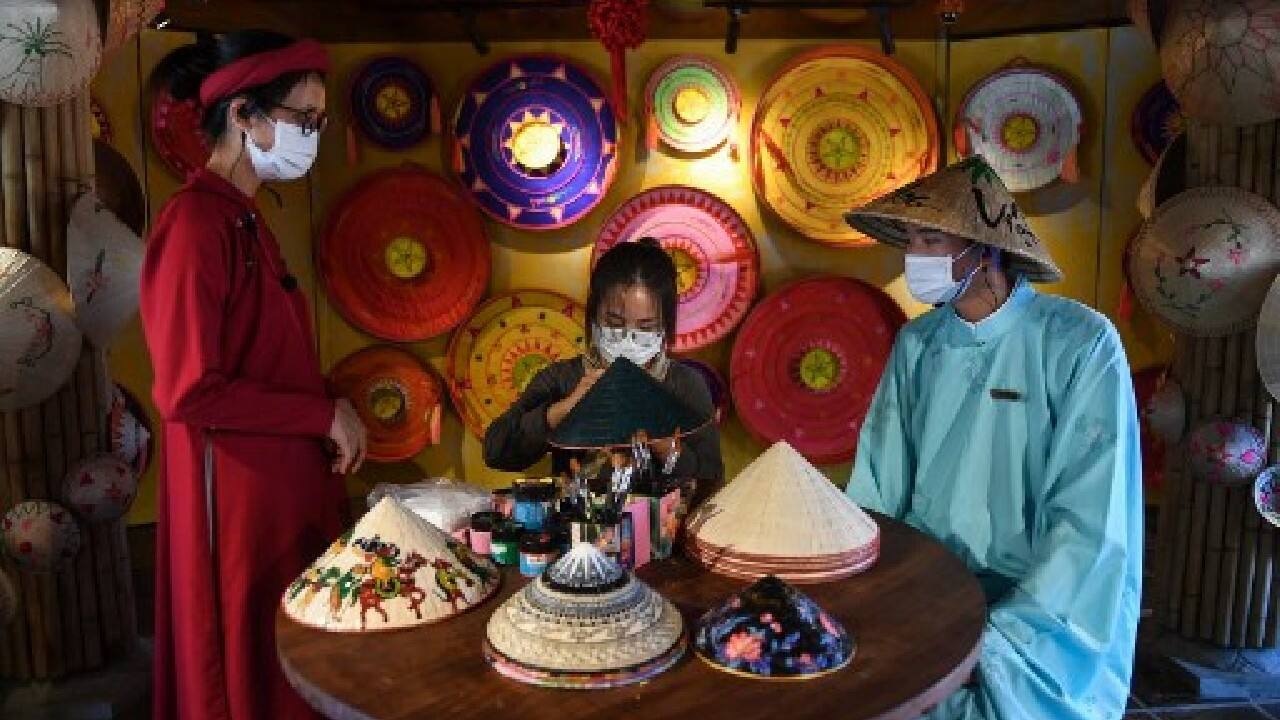 Others busied themselves painting delicate flowers on conical hats. "When we heard visitors were coming back, I was just so excited," said duty manager Ngo Thi Bich Thuong. (Image: AFP) Others busied themselves painting delicate flowers on conical hats. "When we heard visitors were coming back, I was just so excited," said duty manager Ngo Thi Bich Thuong. (Image: AFP)