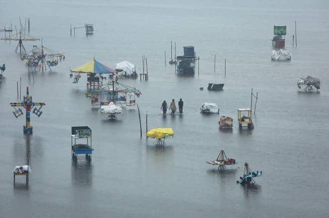 People wade through a flooded beach after heavy rainfall in Chennai, India, November 8, 2021. REUTERS/P. Ravikumar TPX IMAGES OF THE DAY - RC2CQQ9E2SU5
