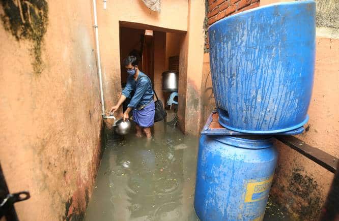 A man collects drinking water from a tap inside his flooded house after heavy rainfall in Chennai, India, November 8, 2021. REUTERS/P. Ravikumar TPX IMAGES OF THE DAY - RC2CQQ9AGHWY