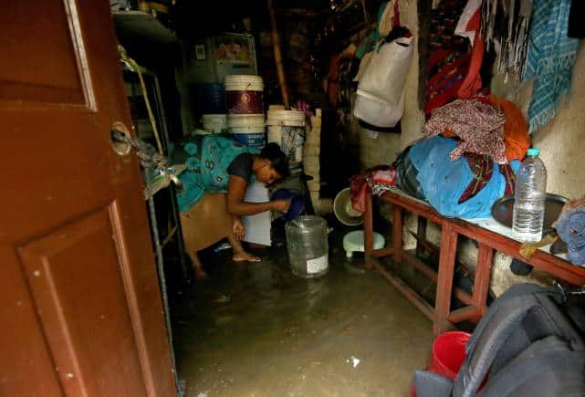 A woman removes rainwater from her house after heavy rainfall in Chennai, India, November 8, 2021. REUTERS/P. Ravikumar - RC2DQQ9IY2I3