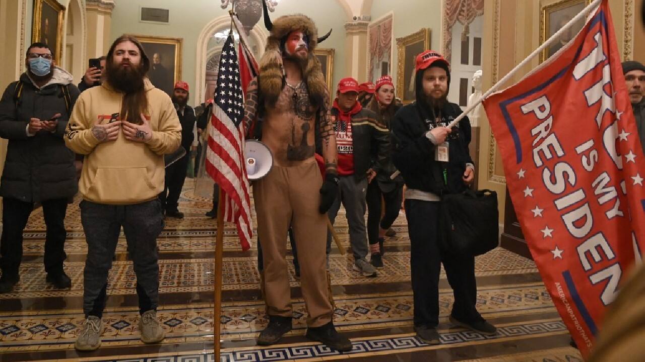 Supporters of US President Donald Trump, including member of the QAnon conspiracy group Jake Angeli, aka Yellowstone Wolf (C), enter the US Capitol on January 6, in Washington, DC. Demonstrators breeched security and entered the Capitol as Congress debated the 2020 presidential election Electoral Vote Certification. (Image: AFP)