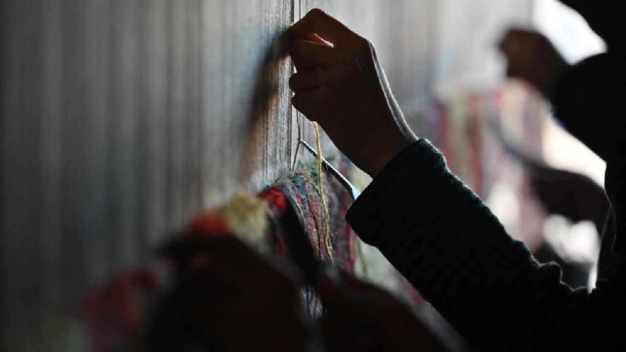 Four Afghan brothers have hauled their family's carpet loom out of storage in the desperate hope of earning a living as the nation's economy teeters on the edge of ruin. The Haidari brothers now spend their days sitting abreast on a squat bench -- as generations of the family did before them -- weaving the complex rugs for which Afghanistan is famed. (Image: AFP)