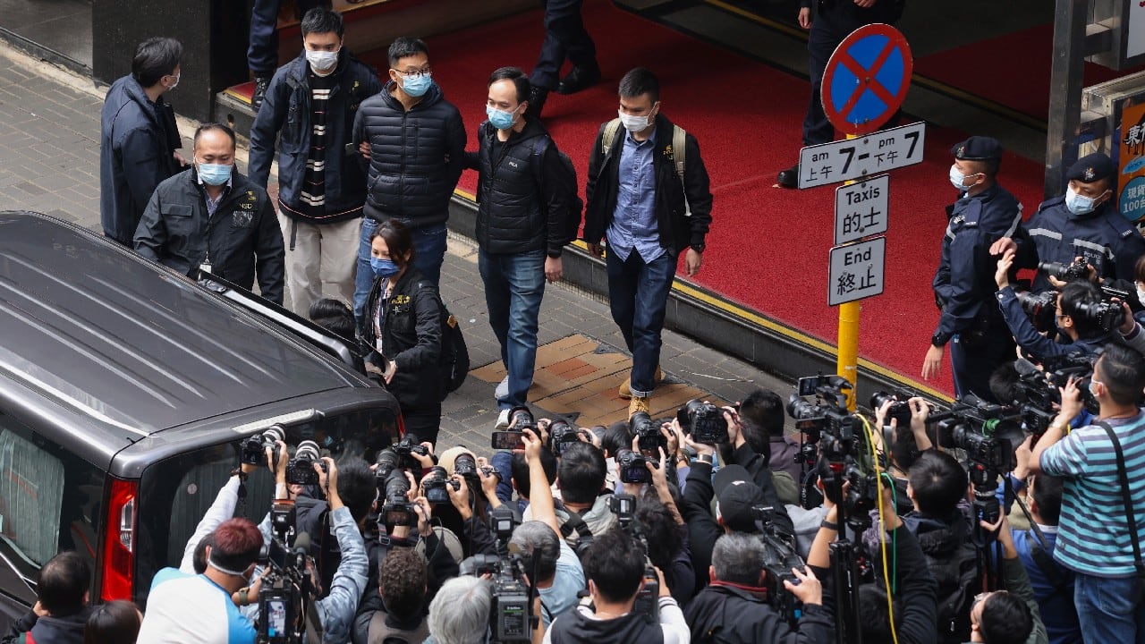 Editor of Stand News Patrick Lam, fourth from left, is escorted by police officers into a van after they searched for evidence at his office in Hong Kong, December 29. Hong Kong police raided the office of the online news outlet on Wednesday after arresting several people for conspiracy to publish a seditious publication. (Image: AP)