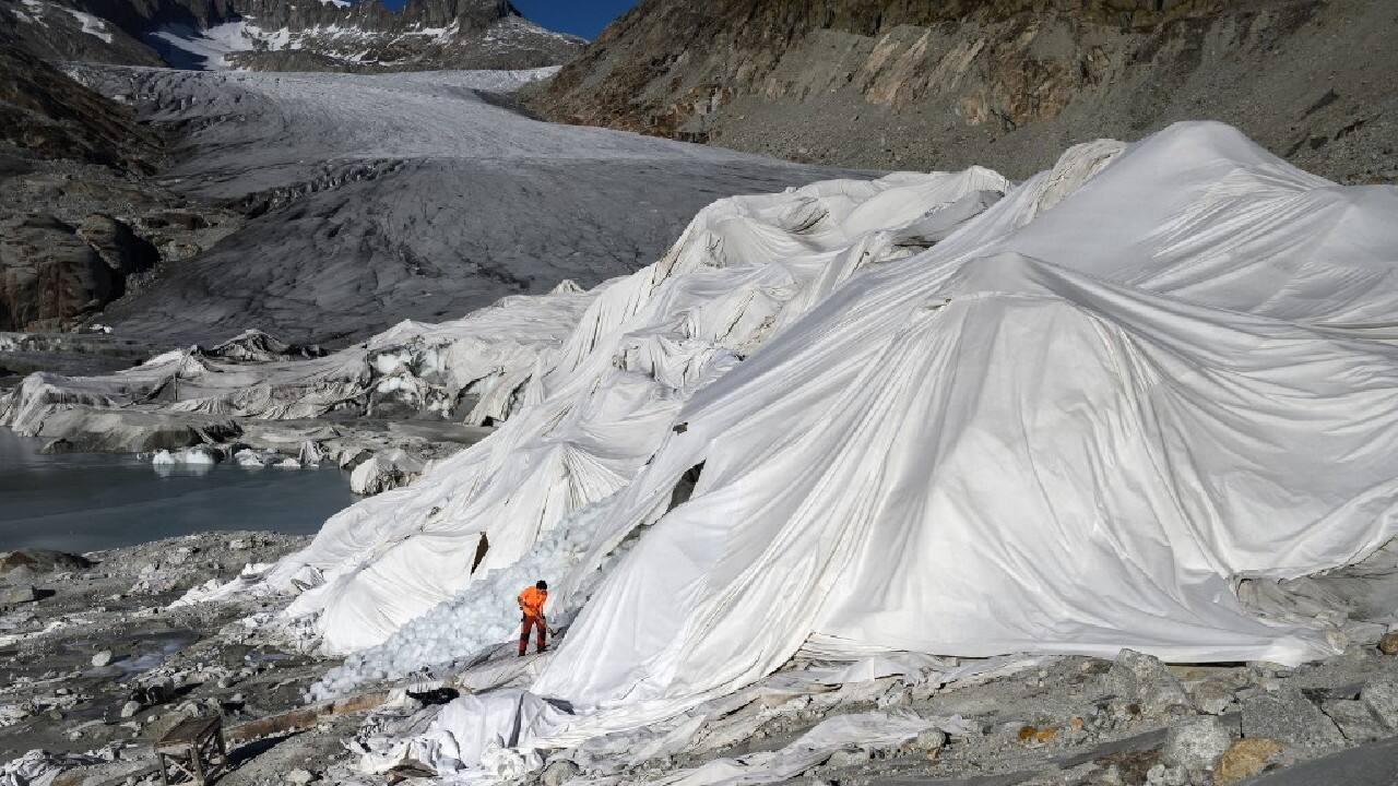 A man works at the Rhone Glacier partially covered with insulating foam to prevent it from melting due to global warming near Gletsch on October 27. Swiss glaciers lost 1 percent of their volume in 2021, despite heavy snow and a cool summer, due to climate change. &quot;Although 2021 shows the lowest ice loss since 2013, no slowdown is in sight for glacier retreat&quot; noted experts from the Expert commission of the cryosphere measurement network of the Swiss Academy of Sciences on October 19. (Image: AFP)