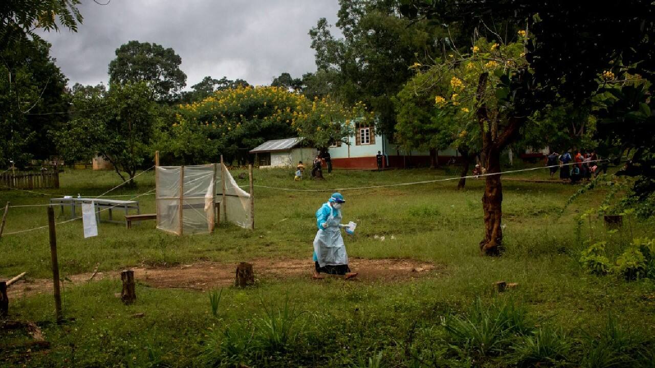 After each shift, Aye Naing removes her plastic protective suit and disinfects it, along with her mask, ready for the next one. In an empty classroom, an infected PDF fighter sits out his quarantine strumming a guitar. (Image: AFP)