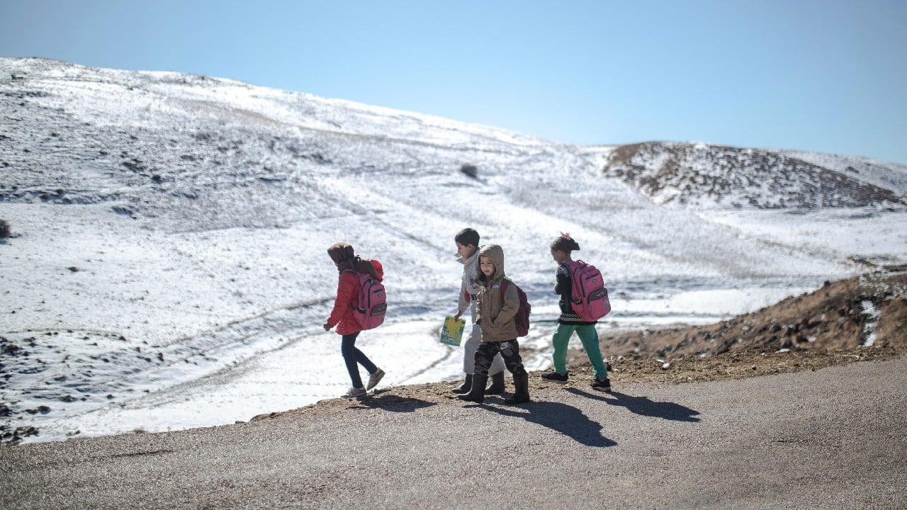 When the snowy weather finally recedes, families try to resume their lives. Children trek along the winding roads to reach the nearest school. (Image: AP)