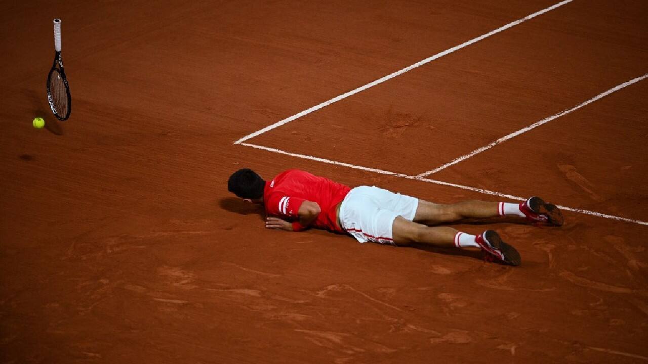 Serbia's Novak Djokovic reacts after falling on the court while playing against Italy's Matteo Berrettini during their men's singles quarter-final tennis match on Day 11 of The Roland Garros 2021 French Open tennis tournament in Paris on June 9. (Image: AFP)