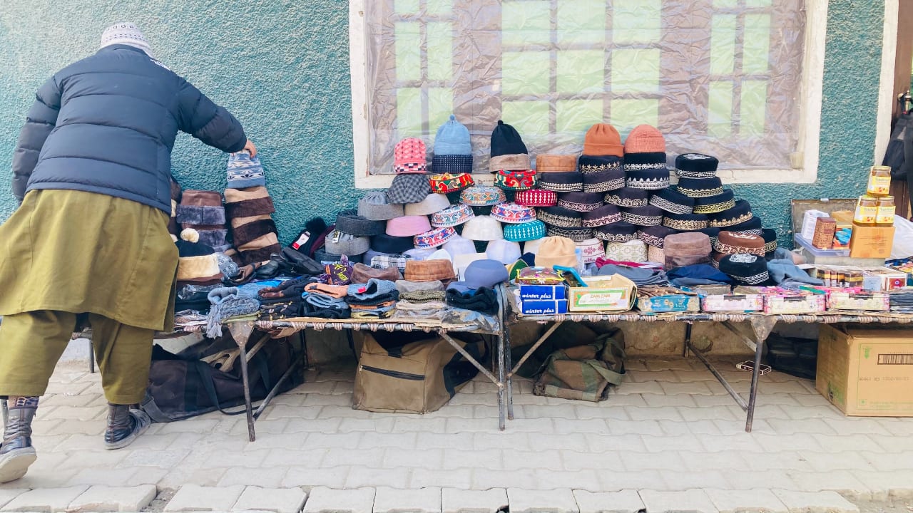 A roadside vendor sells warm caps in TRC Srinagar. Warm caps, mufflers, caps, and gloves are a common sight as temperatures dip below zero. With the onset of Chillai Kalan, the demand for Kangris—traditional fire pots—also increases. People use Kangris under their pherans (woollen cloaks), to keep themselves warm. (Photo by Irfan Amin Malik)