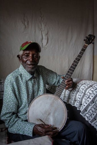 Malawian musician Giddes Chalamanda, 92, poses for a photograph with his acoustic Banjo at his home in the Madzuwa Village near Chiradzulu, southern Malawi.
