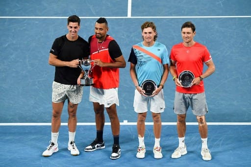 (L to R) Australia's Thanasi Kokkinakis and Australia's Nick Kyrgios pose with the winner's trophy next to Australia's Max Purcell and Australia's Matthew Ebden during their men's doubles final match on day thirteen of the Australian Open tennis tournament in Melbourne on January 29.