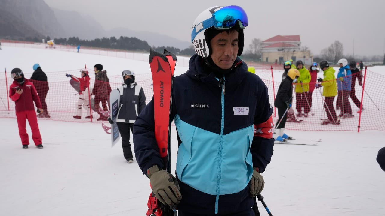 Holding his skis beside a bunny slope, Li Wei enthuses over his winter job as a farmer-turned-ski coach on the northwestern outskirts of Beijing. The tall, tanned 36-year-old works December to March at a resort in the Yanqing district, which will host skiing, luge and other sliding events at the Winter Olympics, which open next week. (Image: AP) Holding his skis beside a bunny slope, Li Wei enthuses over his winter job as a farmer-turned-ski coach on the northwestern outskirts of Beijing. The tall, tanned 36-year-old works December to March at a resort in the Yanqing district, which will host skiing, luge and other sliding events at the Winter Olympics, which open next week. (Image: AP)