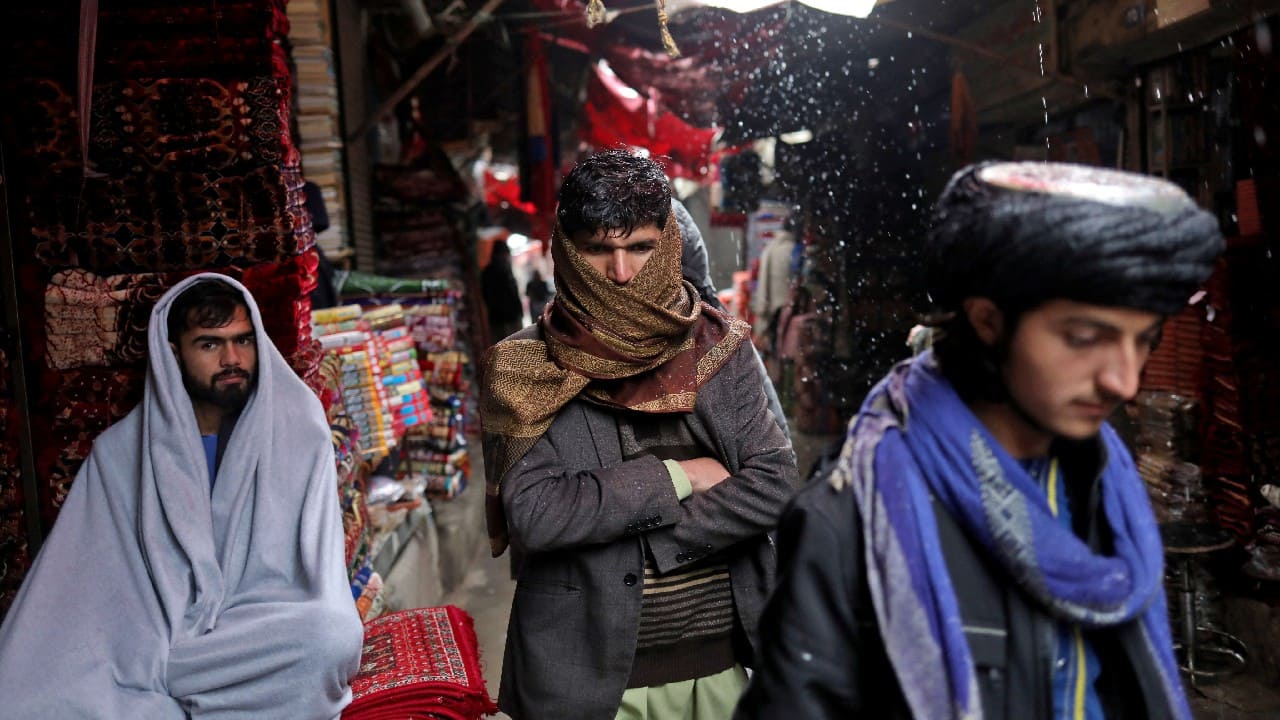 Afghan men walk on a street during a snowfall in Kabul, Afghanistan, January 3. (Image: Reuters)