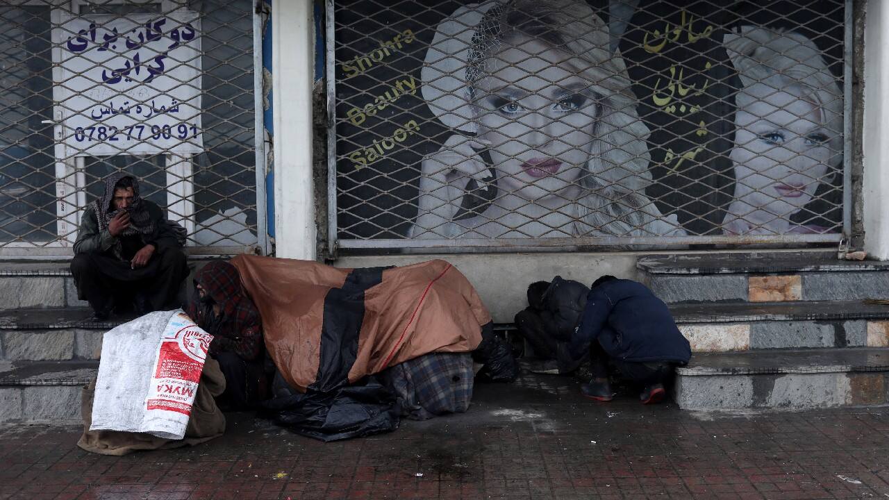 People cover themselves as they sit in front of a beauty salon in Kabul, Afghanistan, January 3. (Image: Reuters)