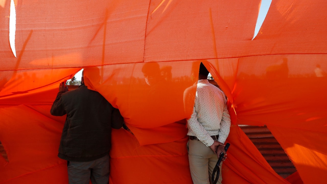 Security personnel look through an opening during an election rally addressed by Uttar Pradesh Chief Minister Yogi Adityanath and Indian Prime Minister Narendra Modi ahead of state elections in Kasganj, India, February 11. (Image: AP)