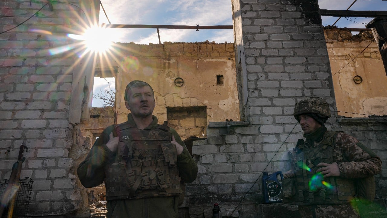 Ukrainian servicemen stand by a destroyed house near the frontline village of Krymske, Luhansk region, in eastern Ukraine, February 19. (Image: AP)