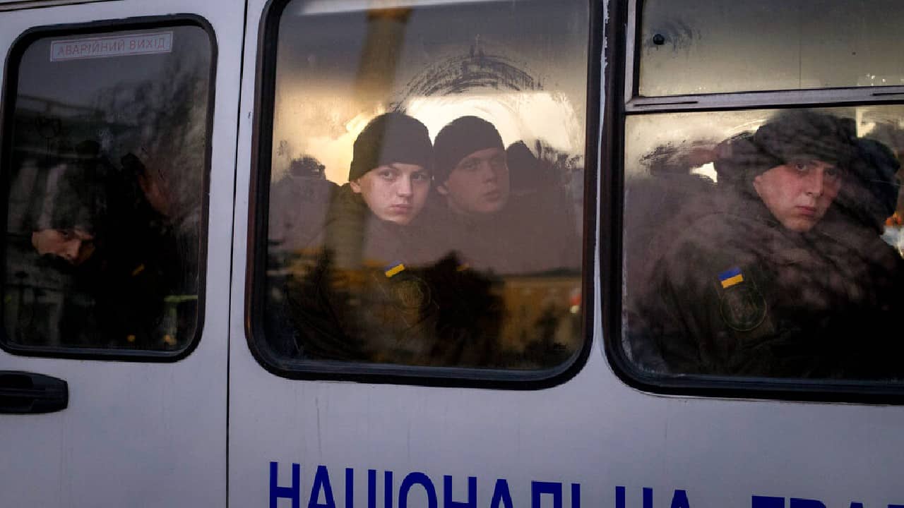 Members of National Guard of Ukraine look out of the window as they ride in a bus through the city of Kyiv, February 14. (Image: AP)