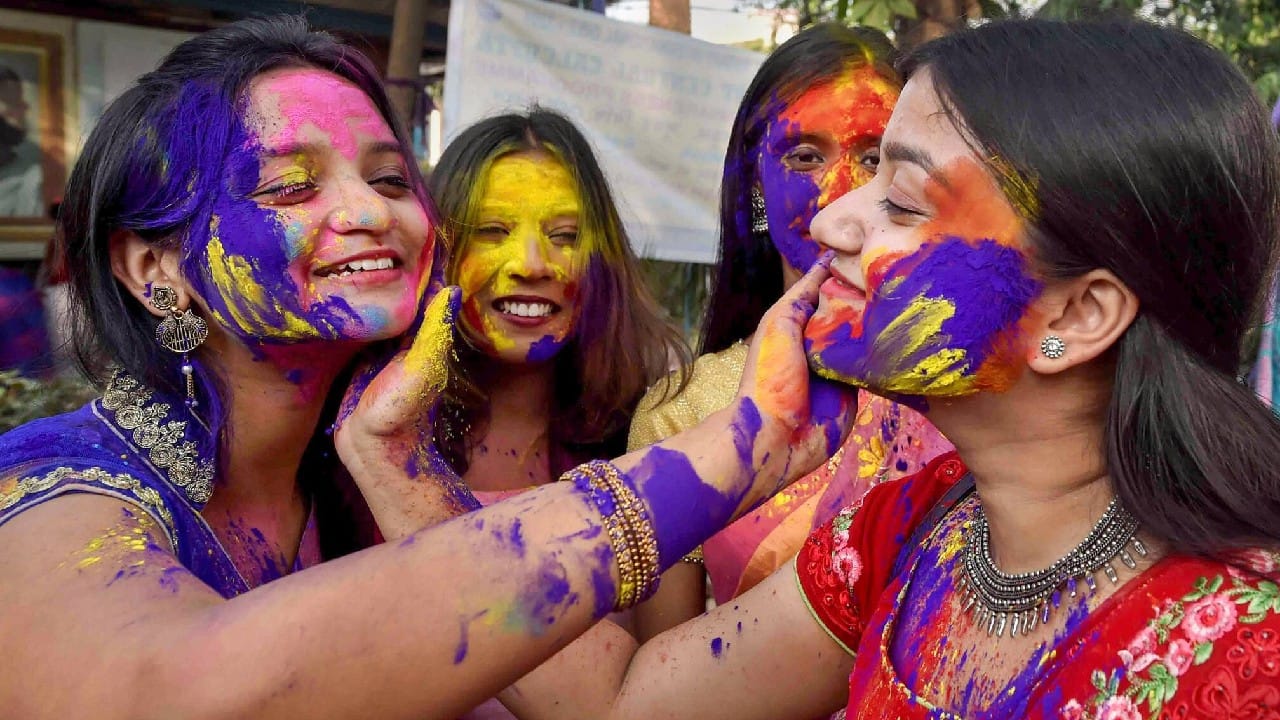 Young women smear colour on each other's faces, in celebration of the festival of 'Holi', in Kolkata, March 17. (Image: PTI)