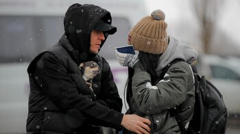 A refugee fleeing the conflict from neighboring Ukraine wipes away tears after seeing a relative at the Romanian-Ukrainian border, in Siret, Romania, March 7. (Image: AP)