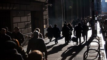 Pedestrians walk along Wall Street near the New York Stock Exchange (NYSE) in New York, U.S., on Monday, Feb. 5, 2018. U.S. stocks remained down after recovering from steeper early losses, while European and Asian equities slumped.