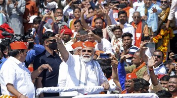 PM Narendra Modi begins a roadshow in Ahmedabad, Gujarat, post BJP's win in four of the five states Assembly election. Riding in an open car decorated with flowers, Modi waved to people during the roadshow from the airport to Kamalam, BJP’s state headquarters in Gandhinagar. (Image: AFP)