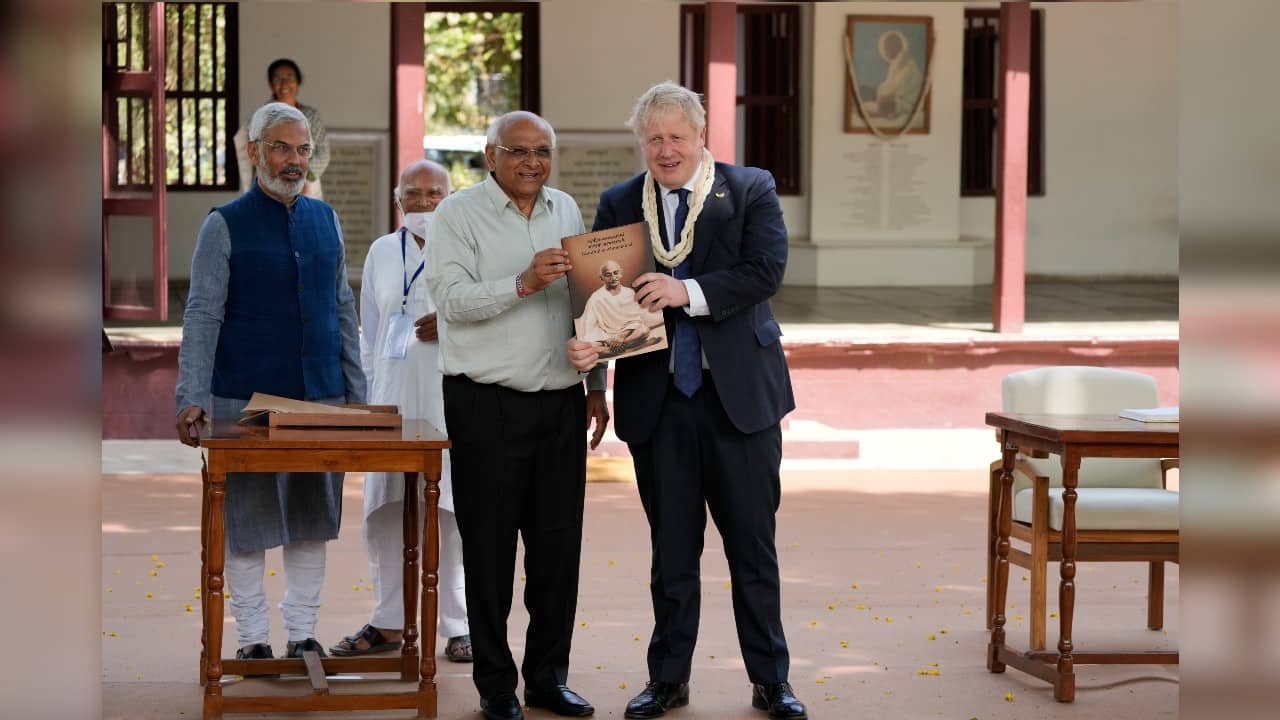 Gujarat state Chief Minister Bhupendra Patel presents a book to British Prime Minister Boris Johnson. (Image: AP)