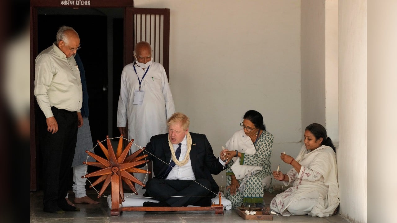 Johnson tries his hands on a spinning wheel during his visit to Gandhi Ashram, which was home to Indian freedom fighter Mahatma Gandhi. (Image: AP)
