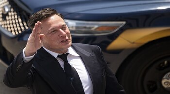 Elon Musk, chief executive officer of Tesla Inc., waves while departing court during the SolarCity trial in Wilmington, Delaware, U.S., on Tuesday, July 13, 2021. Musk was cool but combative as he testified in a Delaware courtroom that Tesla's more than $2 billion acquisition of SolarCity in 2016 wasn't a bailout of the struggling solar provider.