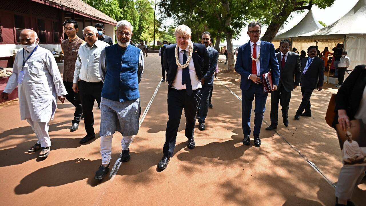 British Prime Minister Boris Johnson walks along with India's environmental educator Kartikeya Sarabhai and the chief minister of Gujarat state Bhupendra Patel during his visit at the Sabarmati Ashram also known as Gandhi Ashram in Ahmedabad, Gujarat on April 21. (Image: AP)