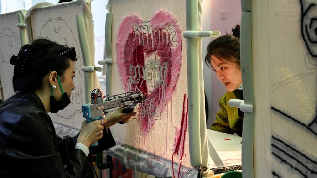 Using a craft gun to shoot yarn through a fabric screen, Nora Peng puts the finishing touches on a rug in the shape of a corgi's bottom -- the perfect stress-relieving hobby for her frantic days. (Source: AFP) Using a craft gun to shoot yarn through a fabric screen, Nora Peng puts the finishing touches on a rug in the shape of a corgi's bottom -- the perfect stress-relieving hobby for her frantic days. (Source: AFP)
