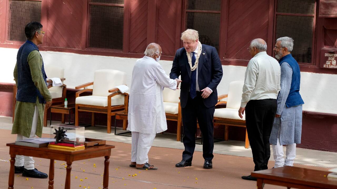 British Prime Minister Boris Johnson is welcomed by Ashram trustee Amrut Modi during his visit to Gandhi Ashram on April 21. (Image: AP)