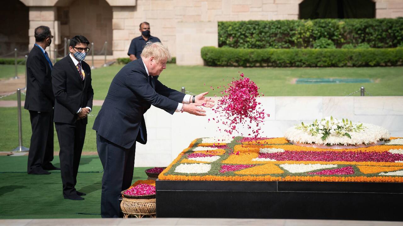 British Prime Minister Boris Johnson offers flower pedals at Gandhi's memorial in tribute to the late Indian leader at Raj Ghat in New Delhi. (Image: AP) British Prime Minister Boris Johnson offers flower pedals at Gandhi's memorial in tribute to the late Indian leader at Raj Ghat in New Delhi. (Image: AP)