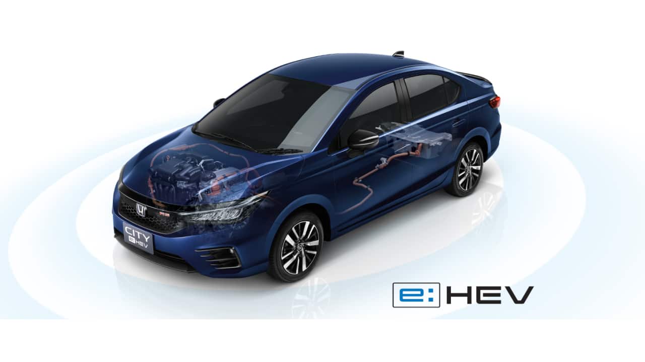 Honda City e:HEV | The full launch date of the City e:HEV has not yet been announced, but the car is all set to be unveiled in India on April 14. In terms of design, the hybrid will see some changes that make the car look sportier. The version that was unveiled in Bangkok a few weeks ago styled itself very closely to the RS variant of the City and as such featured blacked out a blacked out grille along with the RS badge. The front and rear bumpers are different as well and the black accents move up to the outside rear-view mirrors as well. On the inside we are likely to see an all-black theme and the features list will see an upgrade with Honda bringing in the Honda Sensing tech for added safety. This brings in things like emergency braking, lane keep monitoring and assist, adaptive cruise control and more. The Honda City e:HEV will be powered by a 1.5 litre Atkinson cycle engine paired to two electric motors. One will be integrated with the engine to assist and act as a starter generator and the second motor will power the front wheels. This will allow for three driving modes – ICE only, full hybrid and full electric, each selectable using a knob situated on the centre console.