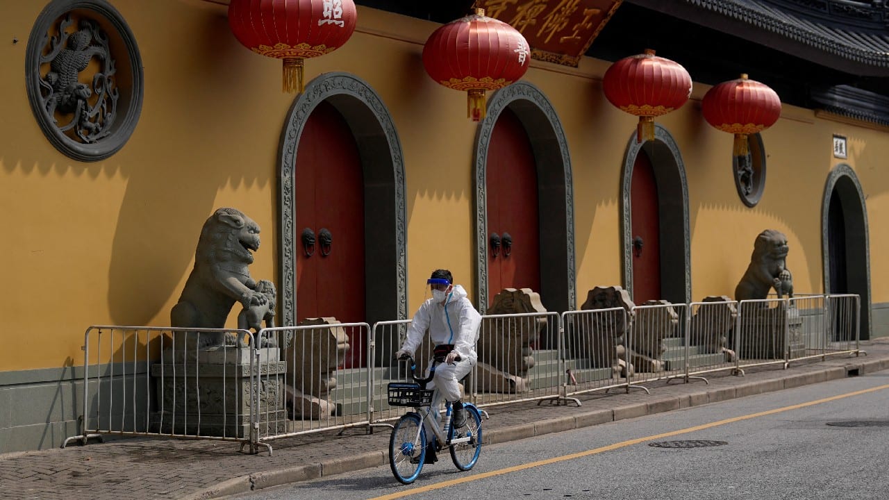 A man rides a bicycle at a closed temple during lockdown, amid the COVID-19 outbreak, in Shanghai, China, May 30. (Image: Reuters)
