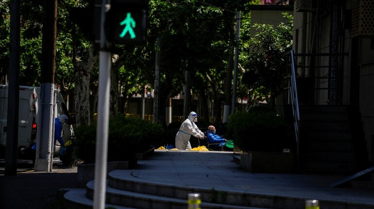 A worker in a protective suit helps an old man with a wheelchair during lockdown amid the coronavirus pandemic, in Shanghai, China, May 5. (Image: Reuters)