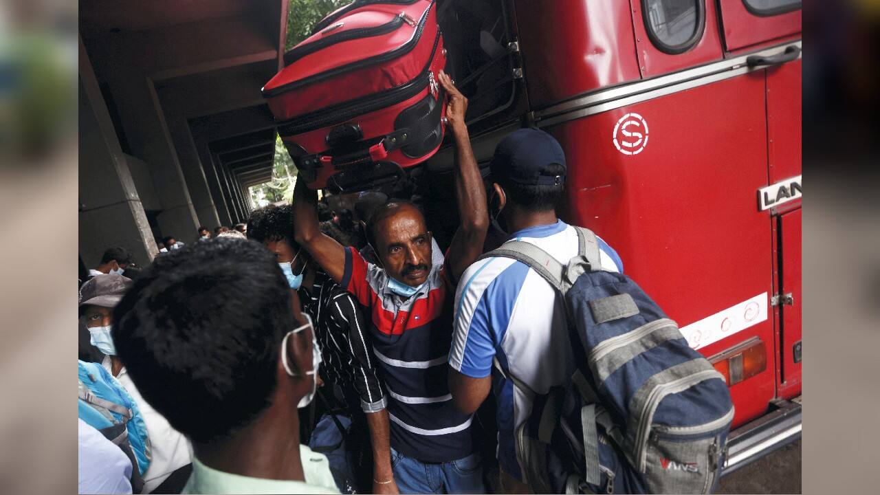 A man carries a suitcase as he arrives to catch a bus before curfew starts, after a clash between anti-government demonstrators and Sri Lanka's ruling party supporters, amid the country's economic crisis, in Colombo, Sri Lanka, May 12. (Image: Reuters)
