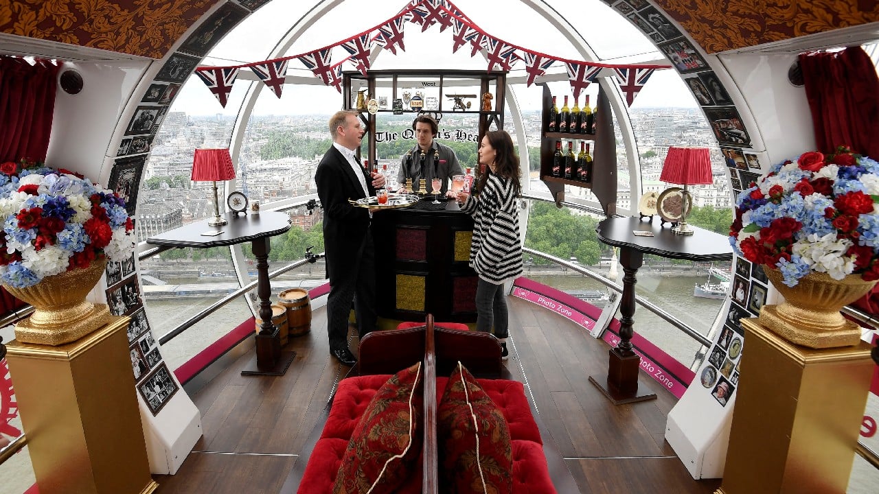 Former butler to the British Royal Family, Grant Harrold poses with employees Harriet Scott and bartender Aiden in a pod of the London Eye themed as a pub from the 1950's ahead of the Platinum Jubilee celebrations for Britain's Queen Elizabeth in London, Britain, May 25. (Image: Reuters)