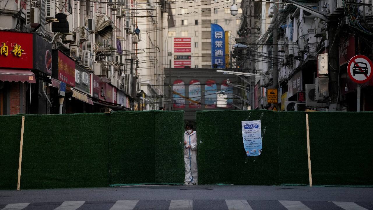A worker in a protective suit locks a barrier of a residential area during lockdown, amid the coronavirus pandemic, in Shanghai, China, May 4. (Image: Reuters)