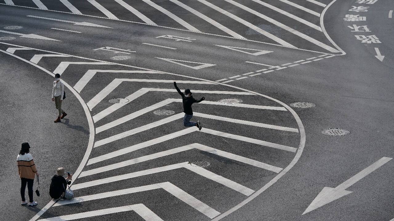 A resident poses for a jump shot below the Lujiazui circular pedestrian bridge in Pudong area, amid the coronavirus outbreak in Shanghai, China May 25. (Image: Reuters)