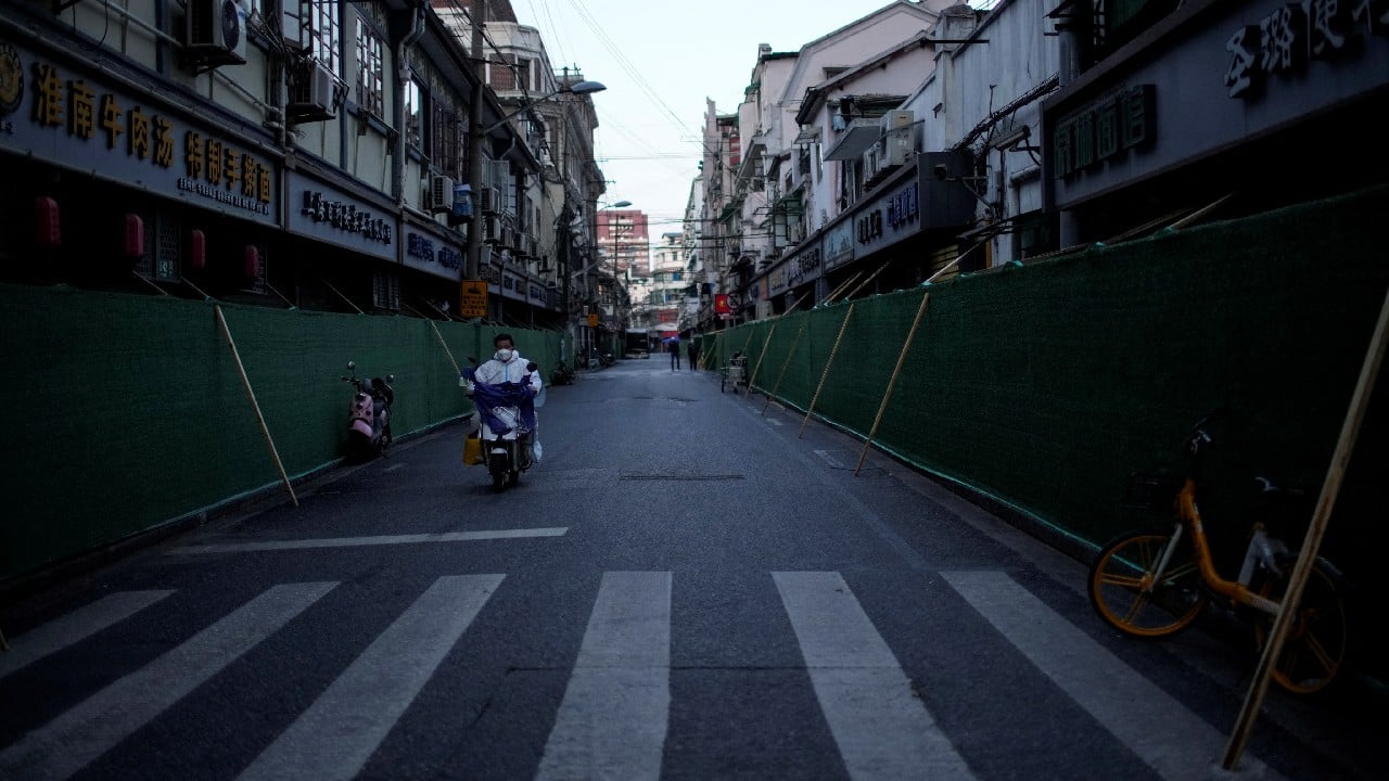 A man in a protective suit rides an electric scooter on a street during lockdown, amid the outbreak, in Shanghai, China, May 4. (Image: Reuters)